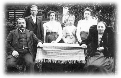 Urgroßvater (1864) mit Familie, Hintergrund Wohnhaus - 1912