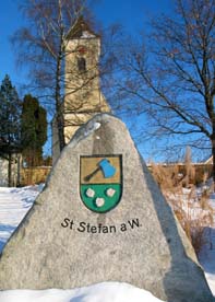 Wappenstein von St. Stefan am Walde mit Hintergrund Kirchturm